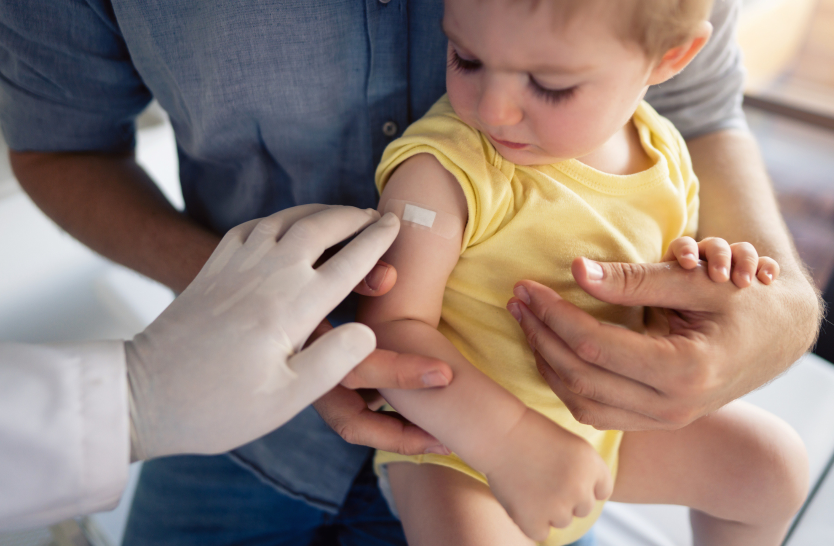 Child on a parents lap after receiving the flu vaccine