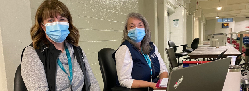 two masked staff members working at covid vaccine clinic